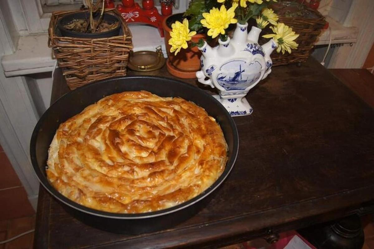 a pie in a pan on a table with a vase