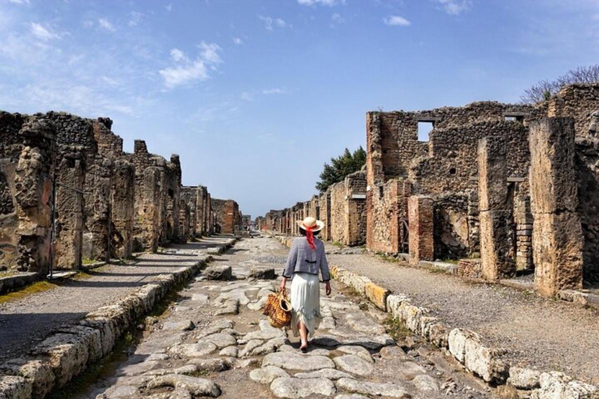 una donna che cammina lungo una strada tra le rovine