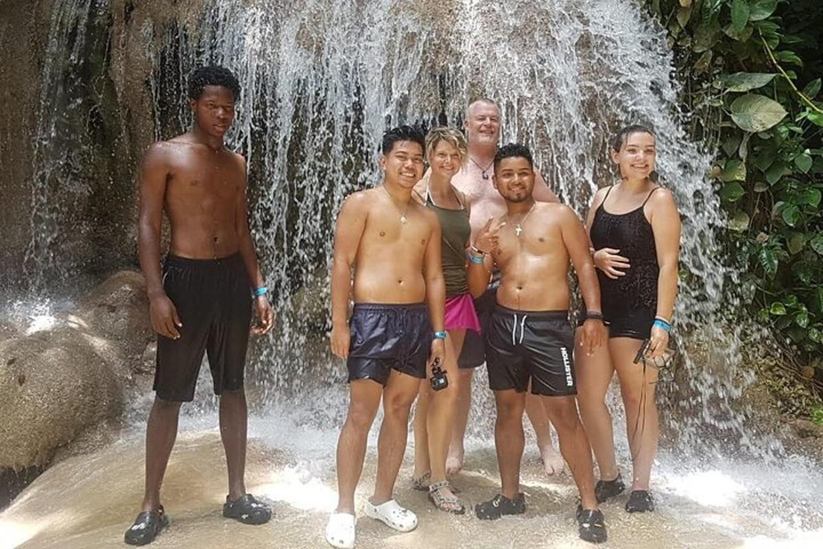 a group of people standing in front of a waterfall