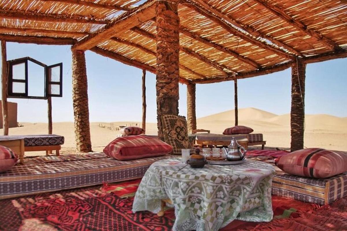 a tent with pillows and a table in the desert