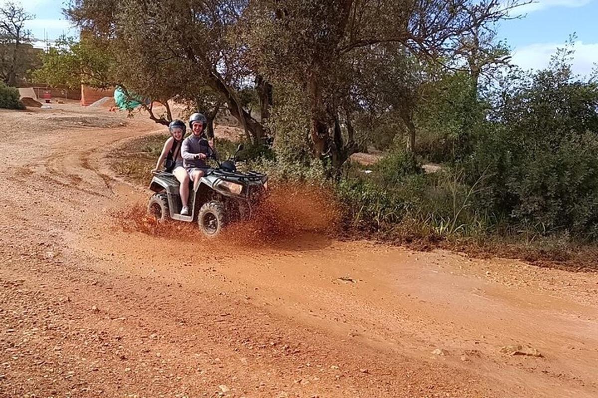 deux personnes conduisant une moto tout-terrain sur un chemin de terre