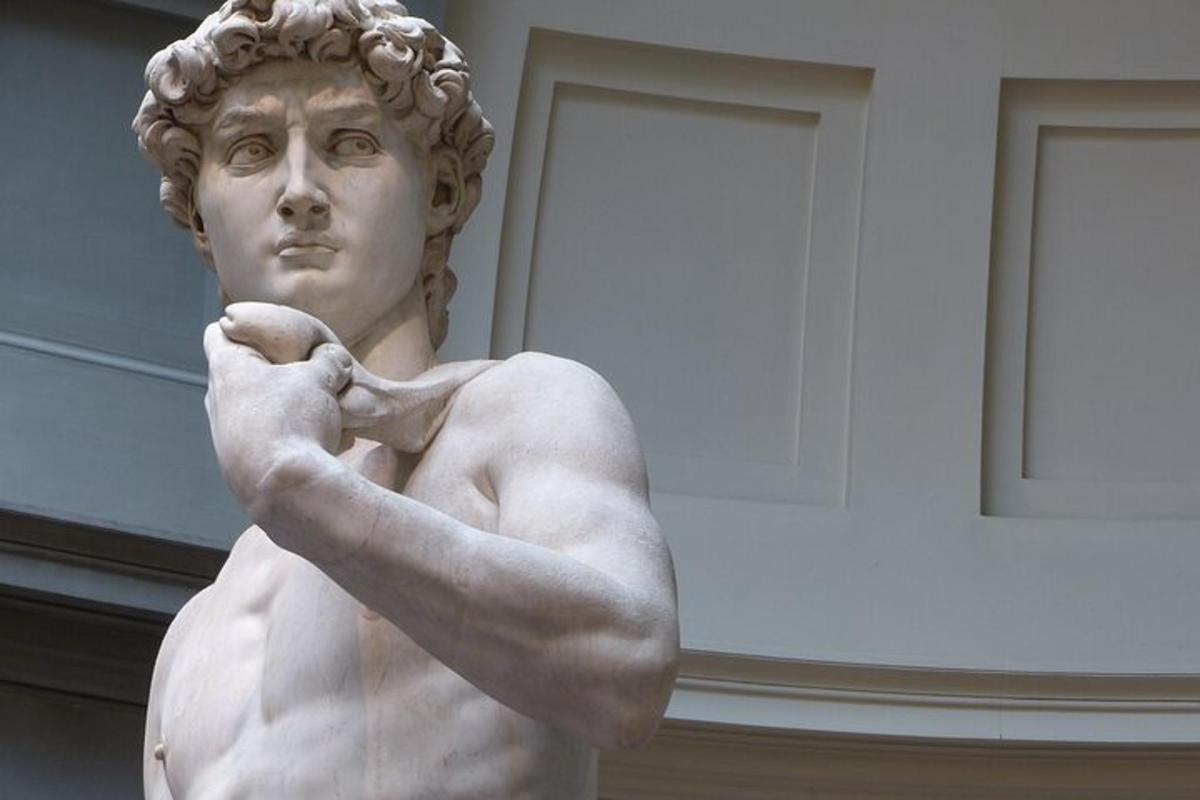 uma estátua de um busto de um homem com a mão defensivamente