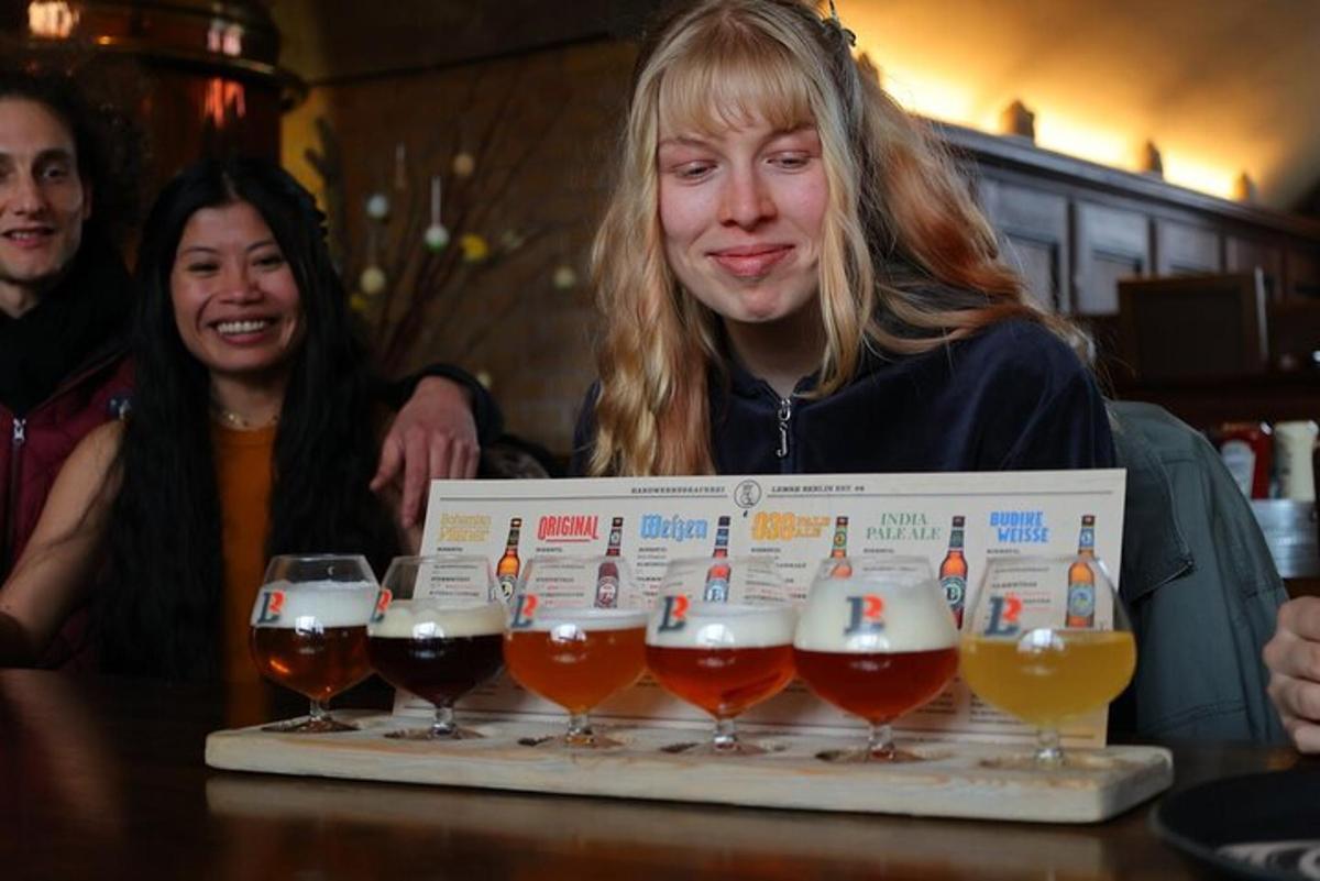 a woman holding a box with four glasses of beer