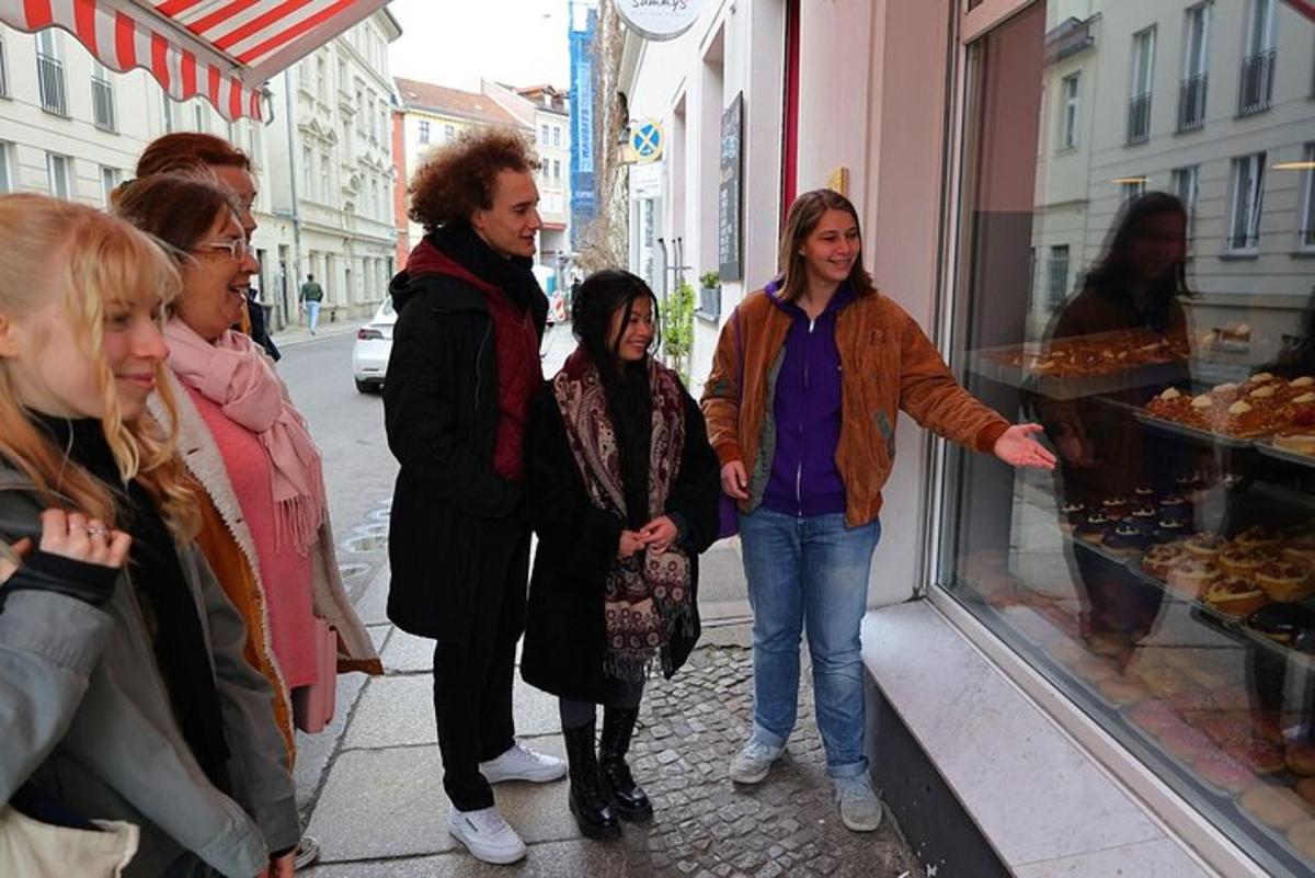 a group of people standing outside of a bakery window