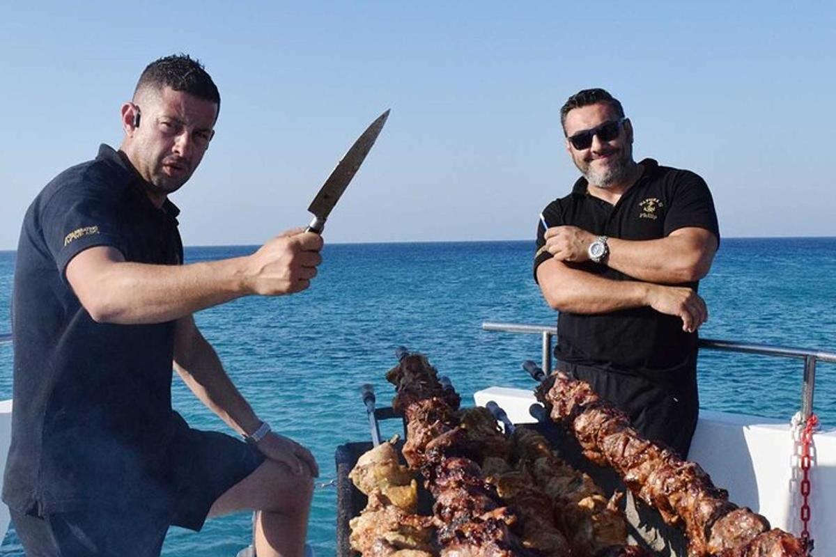 dvaja muži stojaci vedľa grilu s nožom