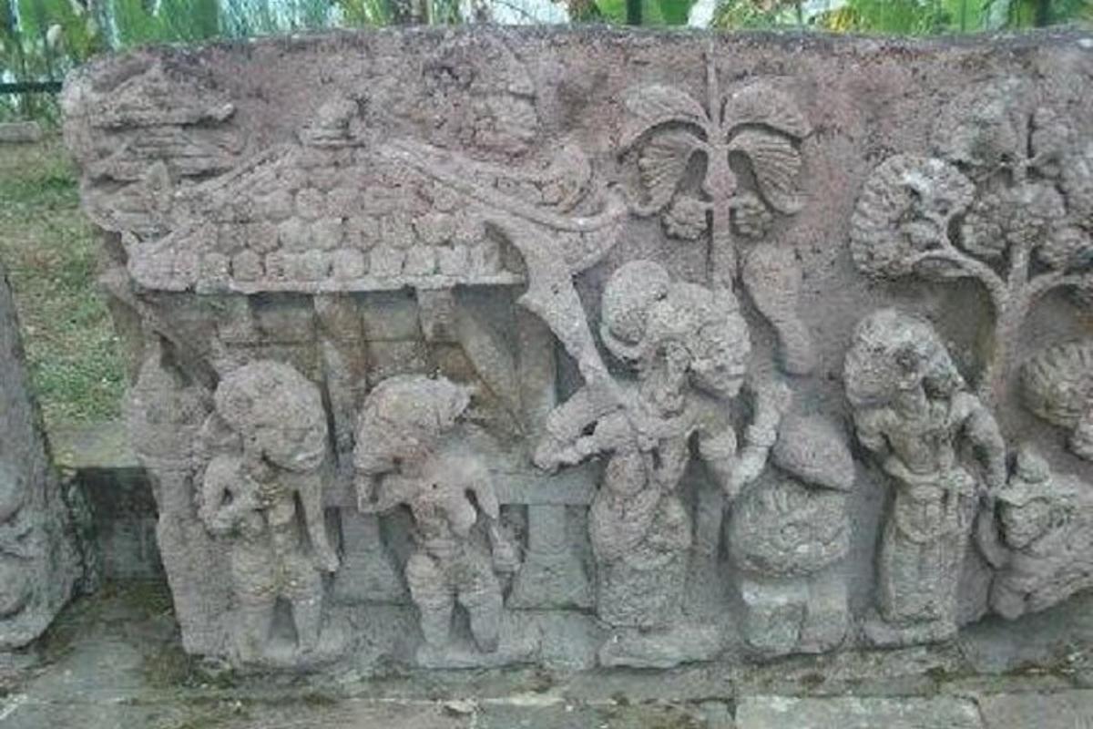 dinding batu dengan relief anak-anak di atasnya
