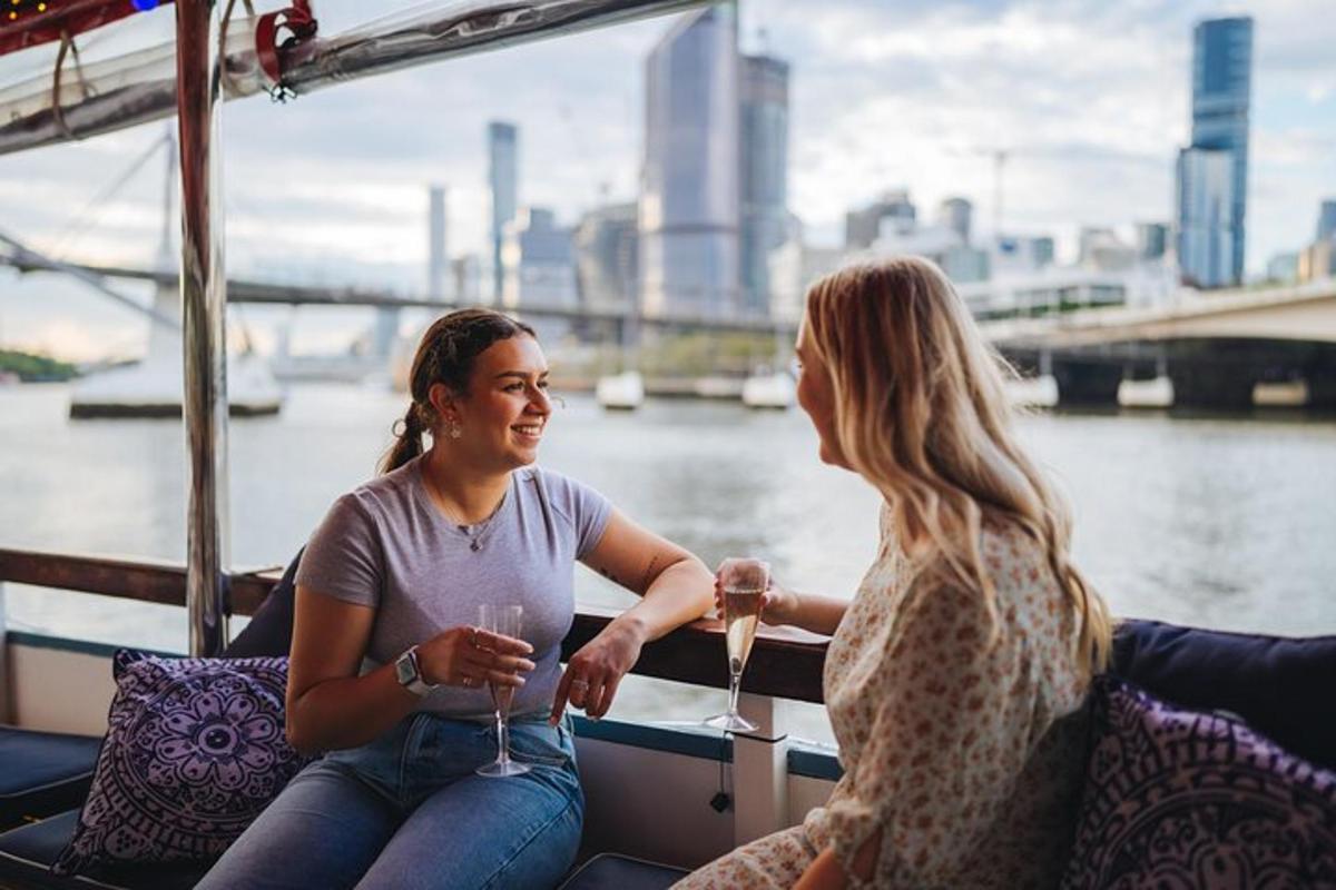 two people sitting on a boat with wine glasses