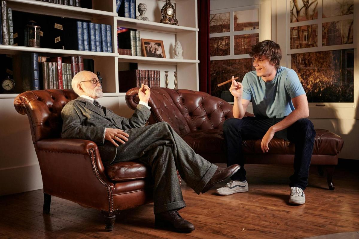 two men sitting on a couch playing a video game