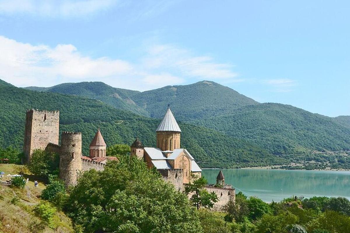 un castello su una collina vicino a uno specchio d'acqua