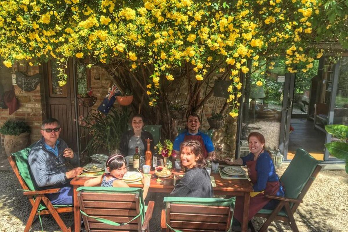 skupina lidí sedících u stolu pod stromem
