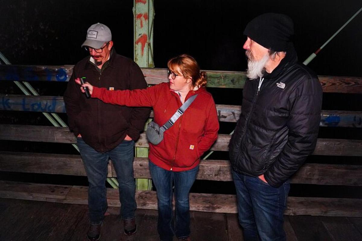 skupina tří lidí dívajících se na mobilní telefon