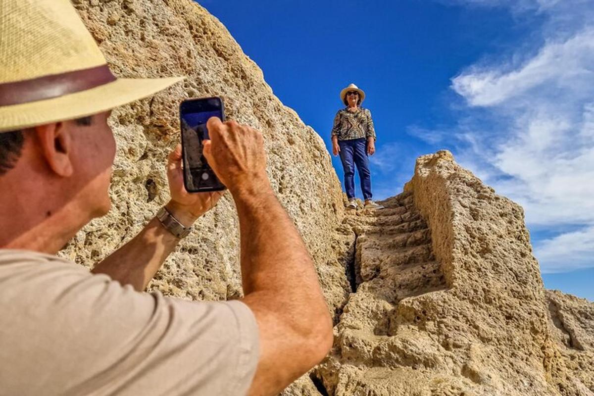 muž fotografující muže stojícího na skále