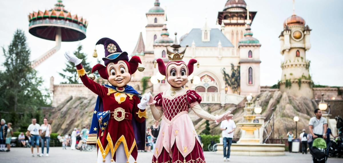 two people dressed in costumes in front of a castle