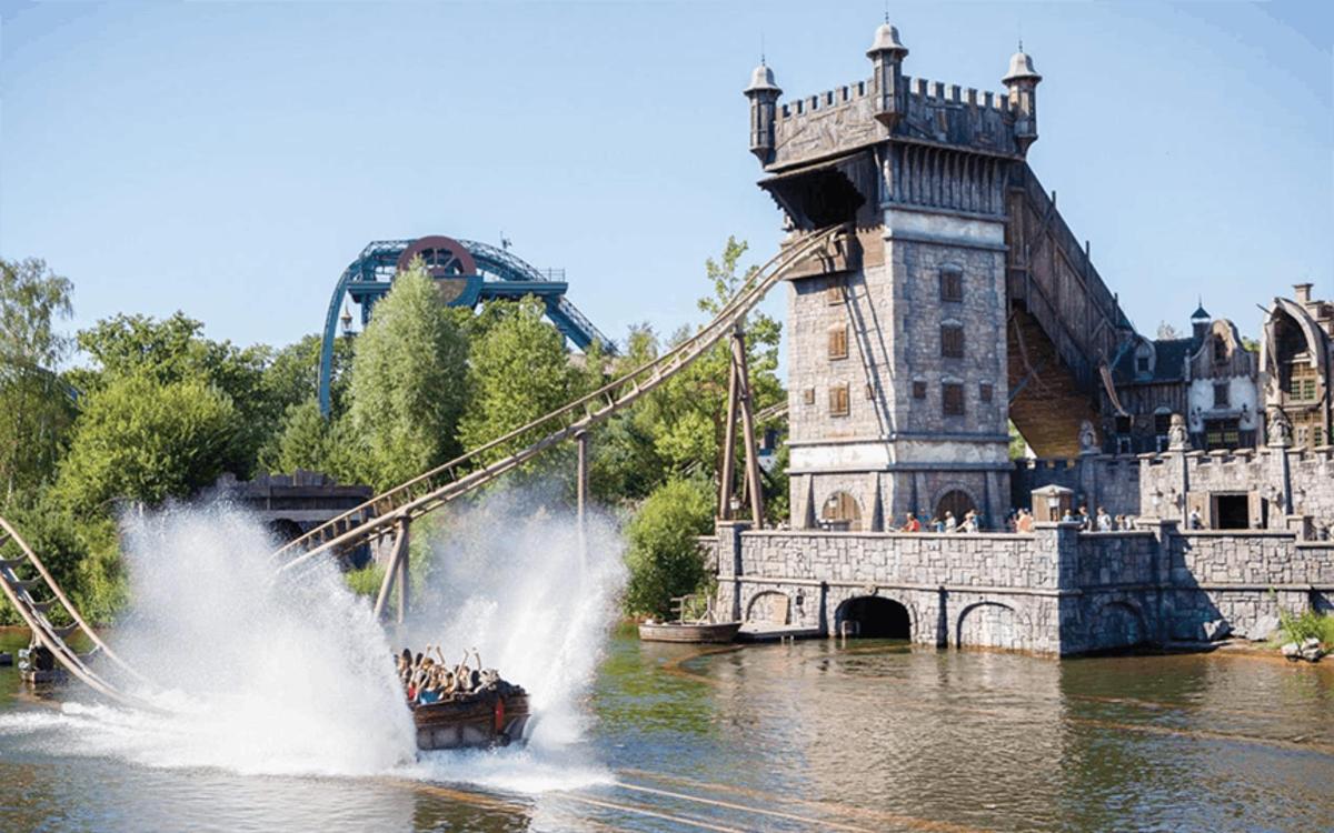 a group of people in a boat in the water near a bridge