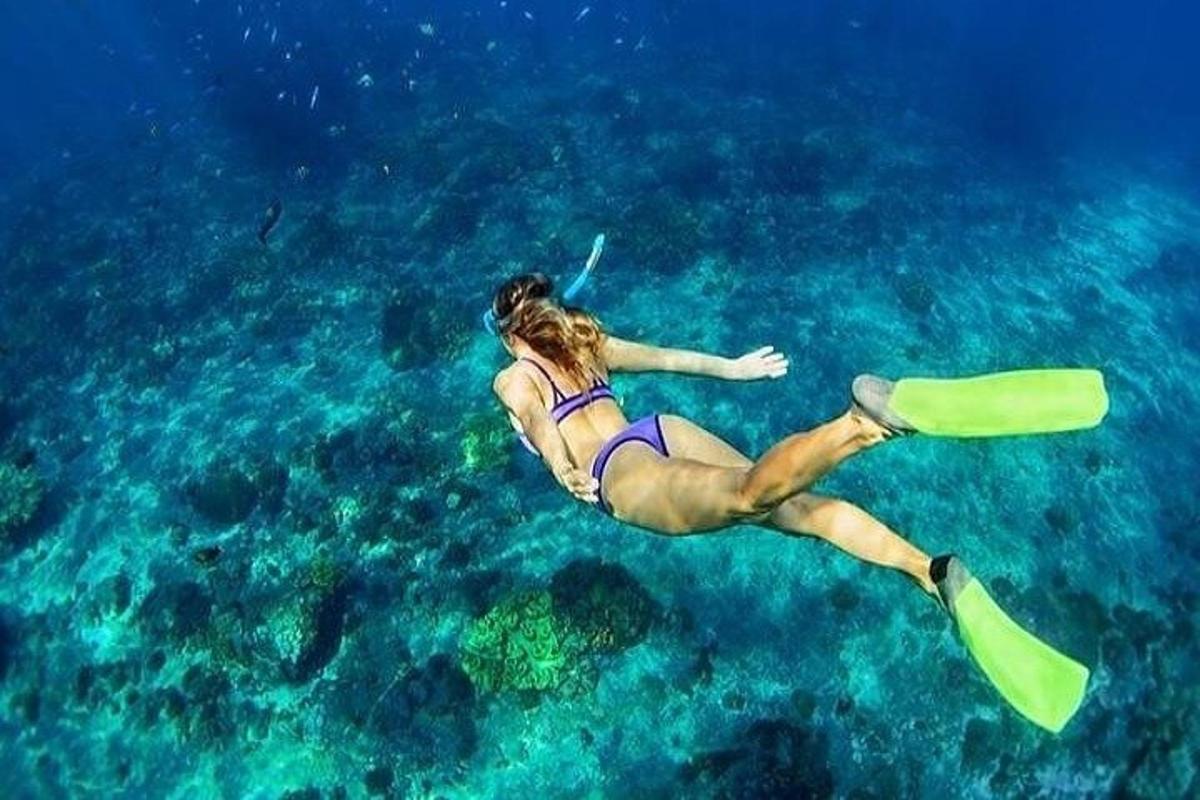 una donna sta nuotando nell'acqua con uno snorkeling
