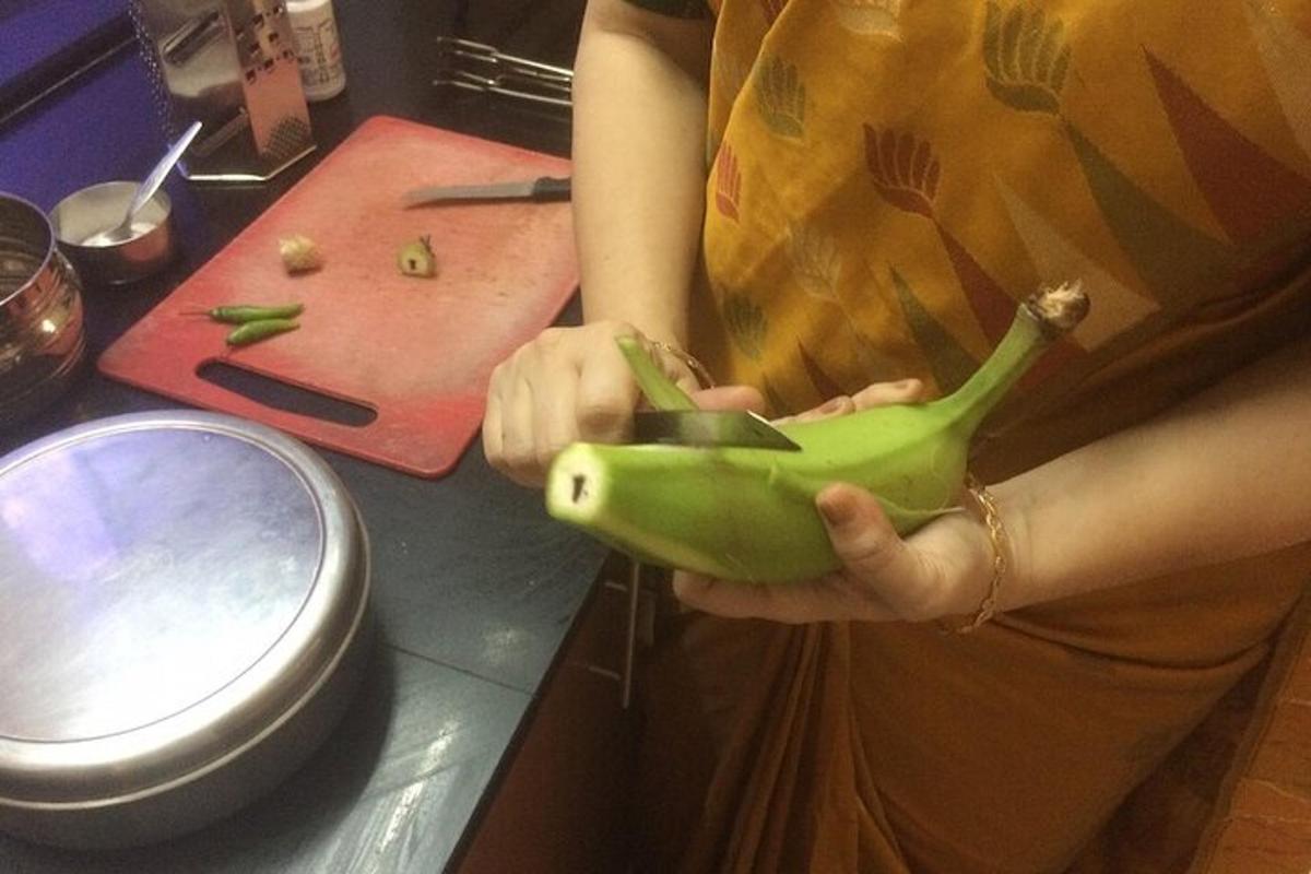 a woman holding a green banana in a kitchen