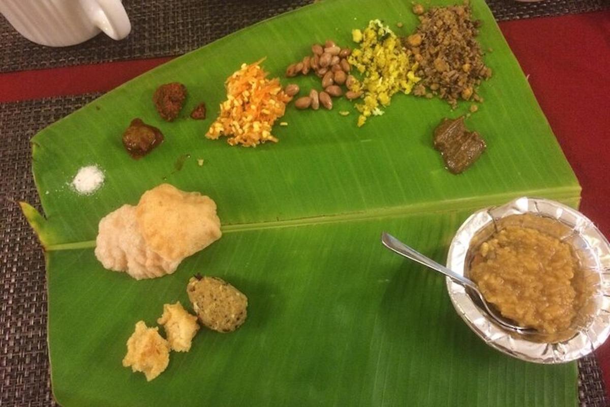 a green plate of food on a banana leaf