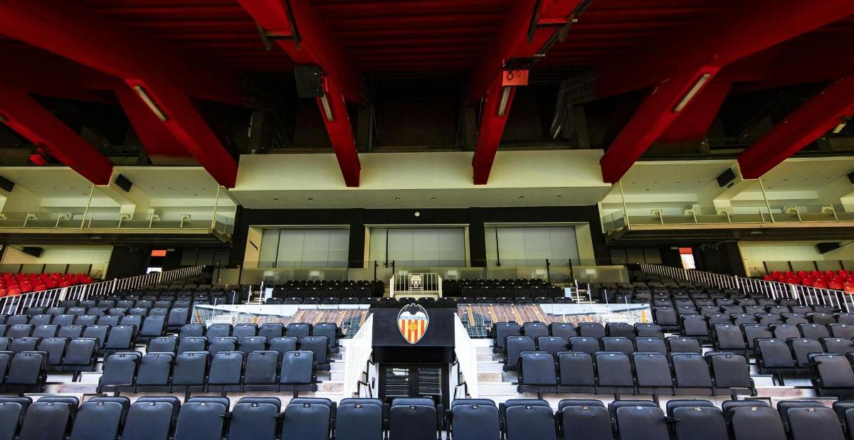 an empty auditorium with blue chairs and a stage