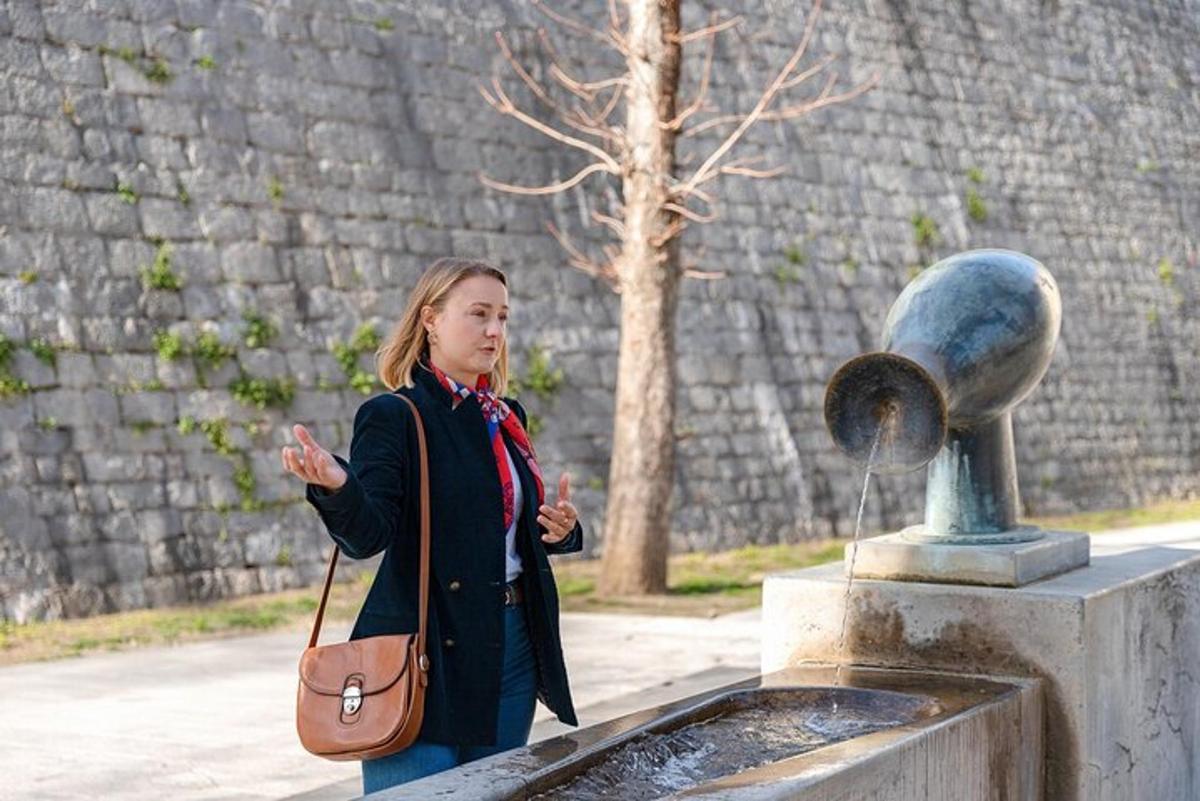 žena stojí vedle fontány