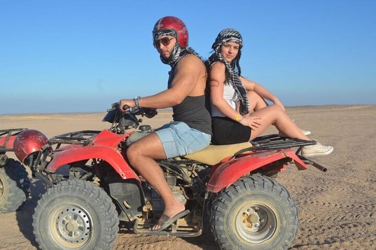 een man en een vrouw zitten op quads in de woestijn
