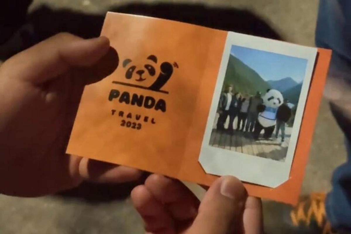 a person holding a card with a picture of panda family