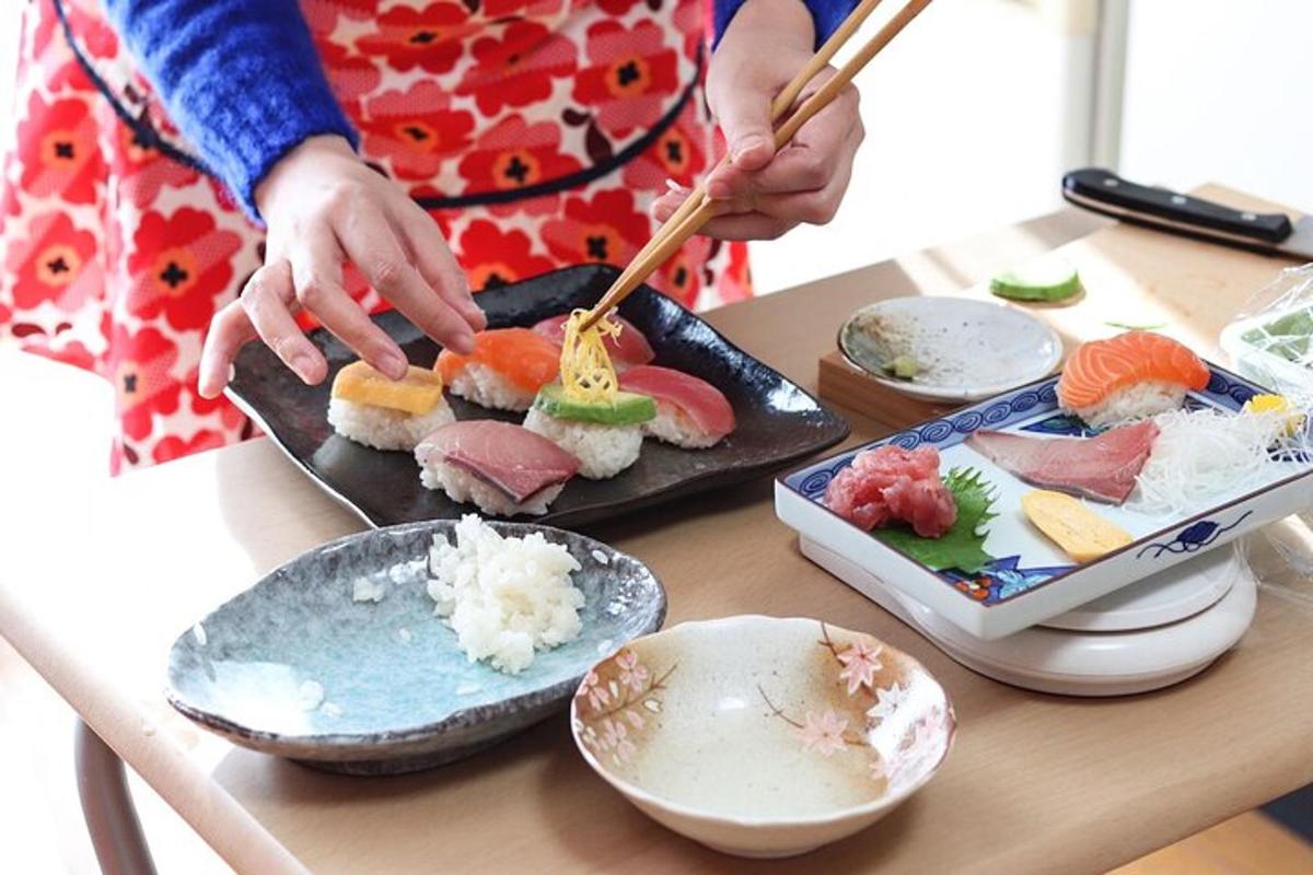 Žena připravuje sushi na stole hůlkami