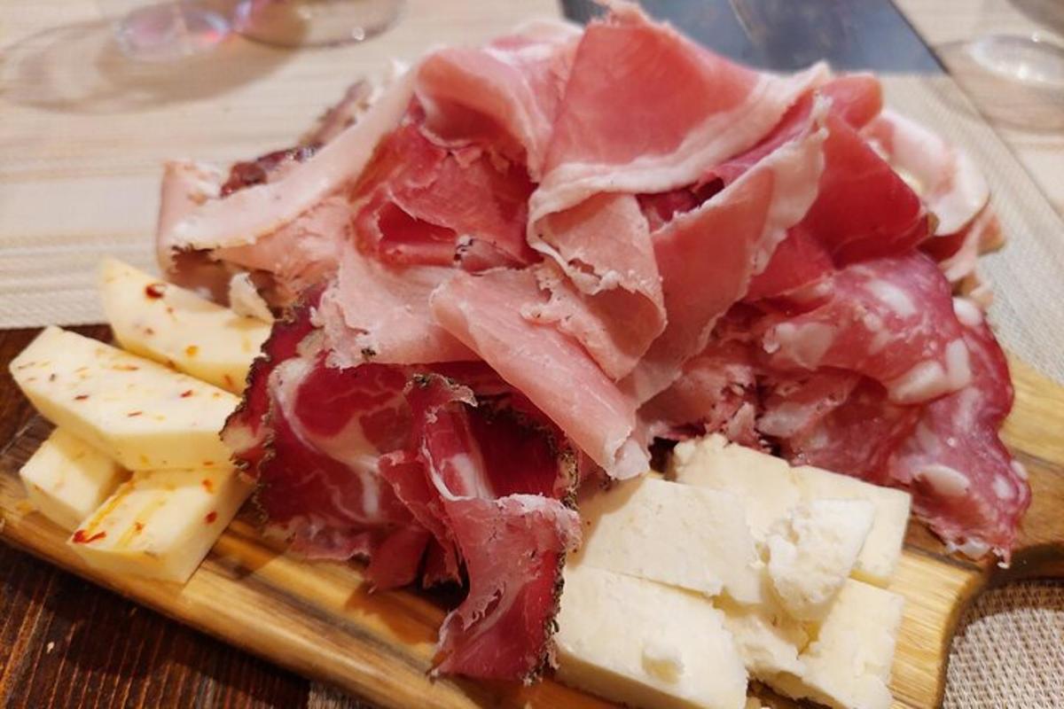 a pile of meat and cheese on a cutting board