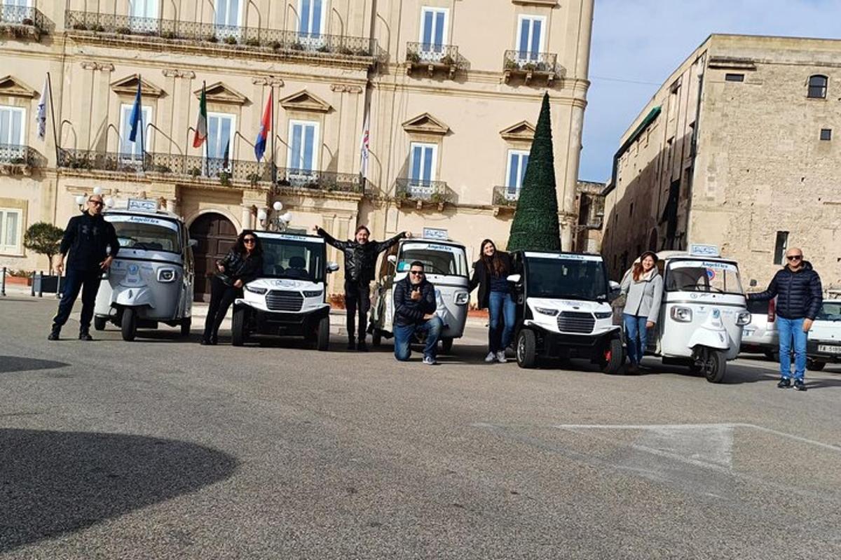 a group of people standing in front of their cars