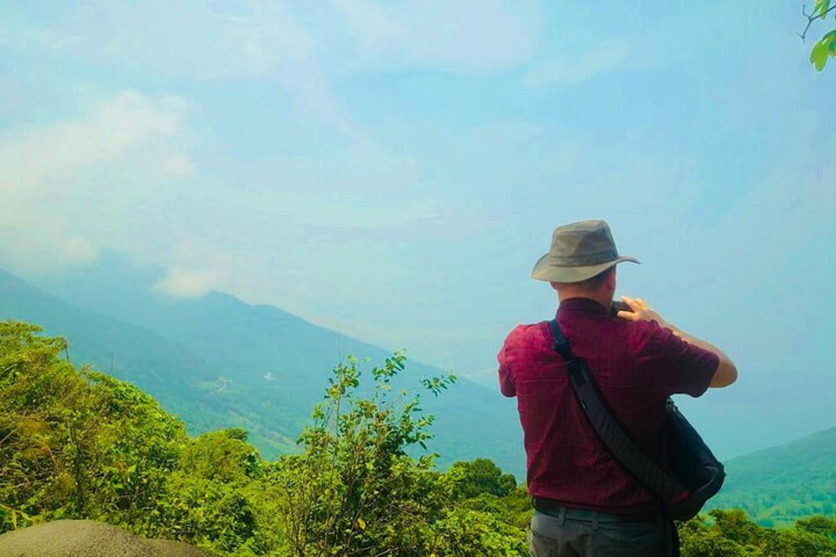 um homem em pé no topo de uma montanha tirando uma foto