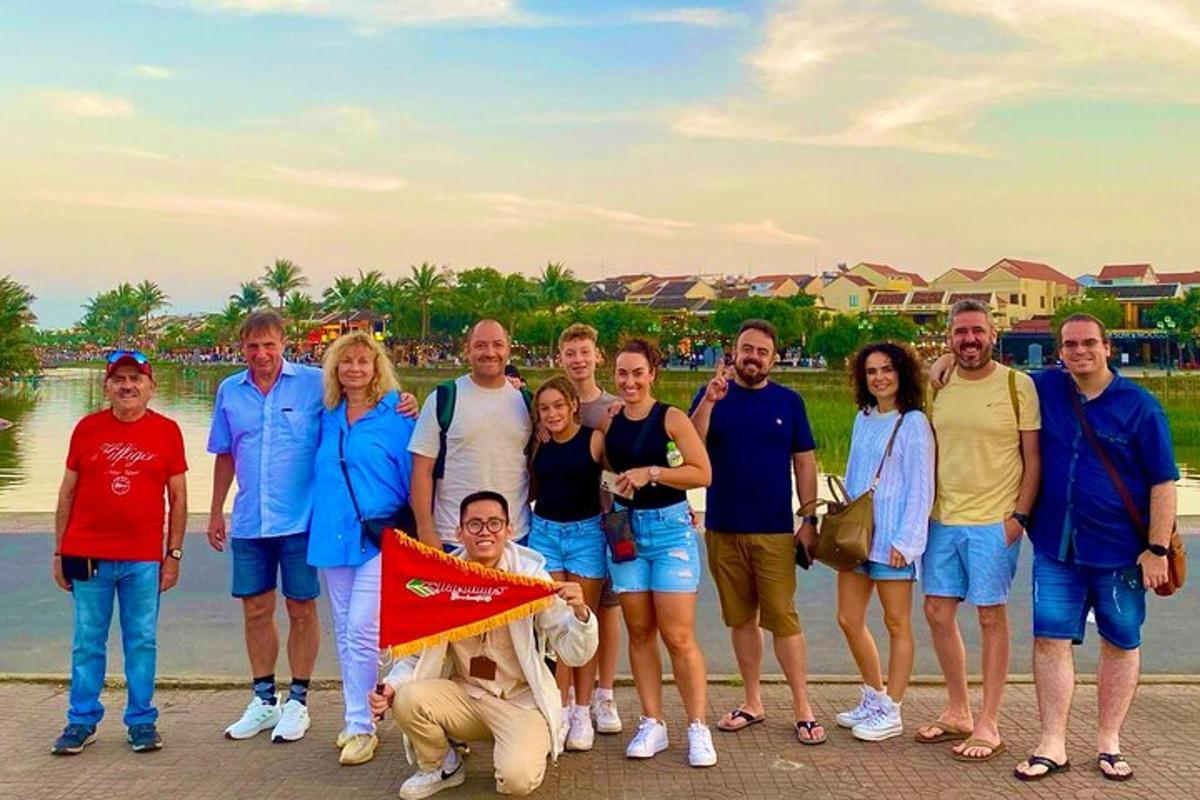 a group of people posing for a picture next to the water