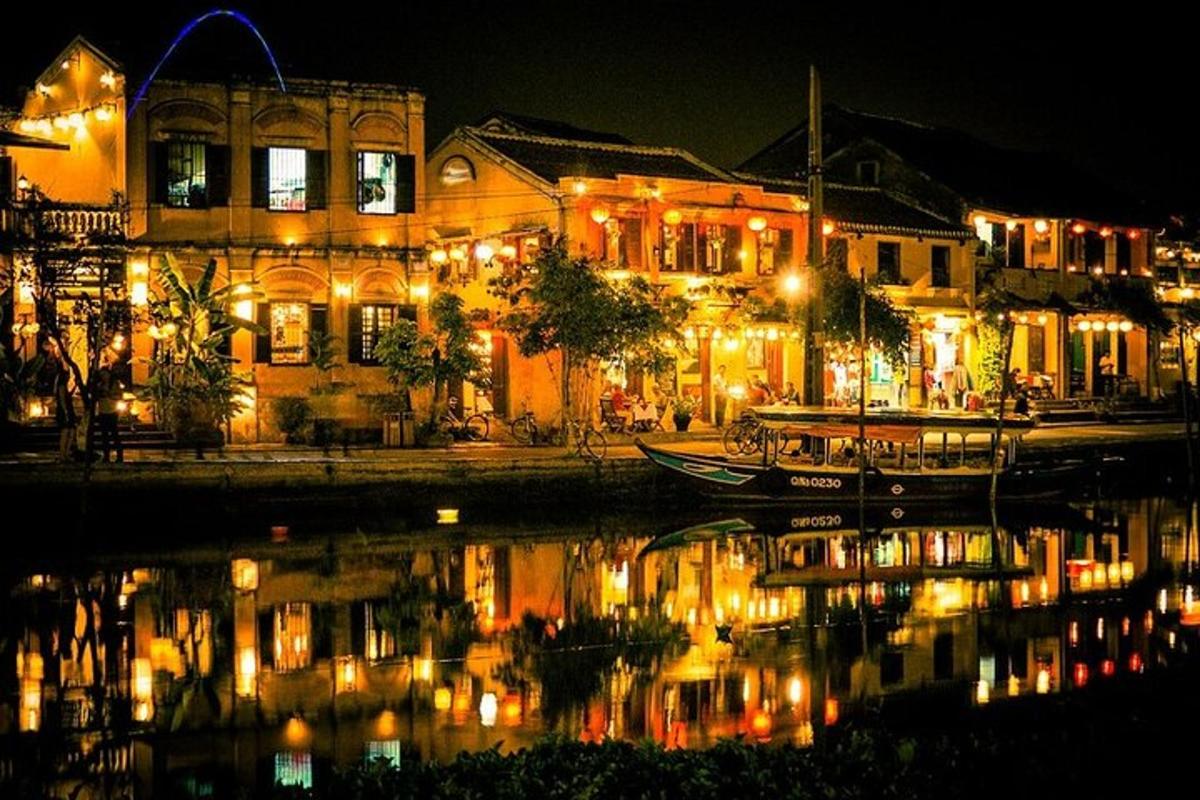 a city lit up at night with a boat in the water