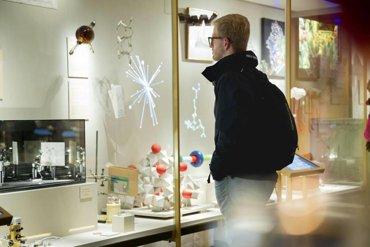 a man looking at a display case in a store