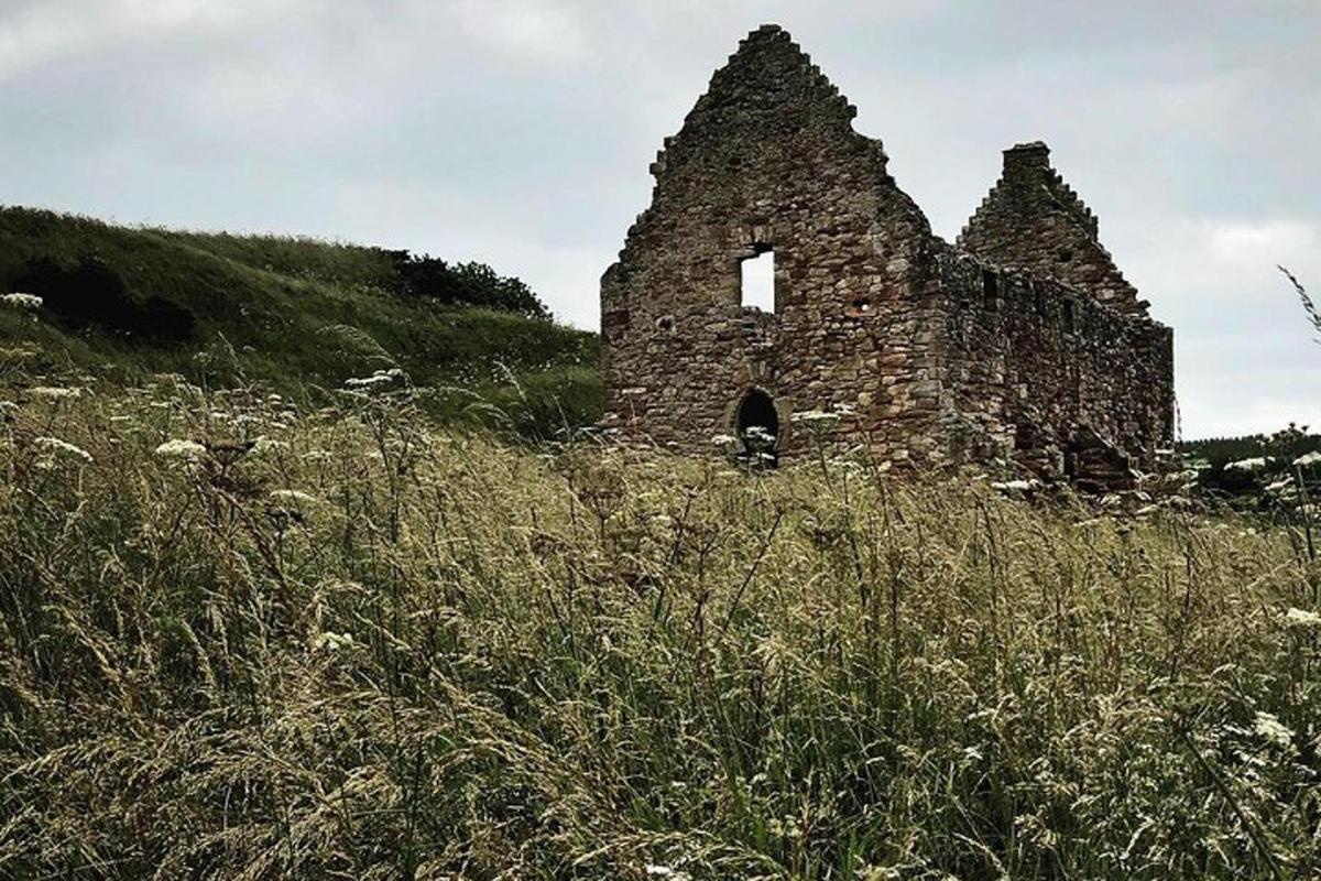 un vecchio edificio situato in cima a un campo erboso