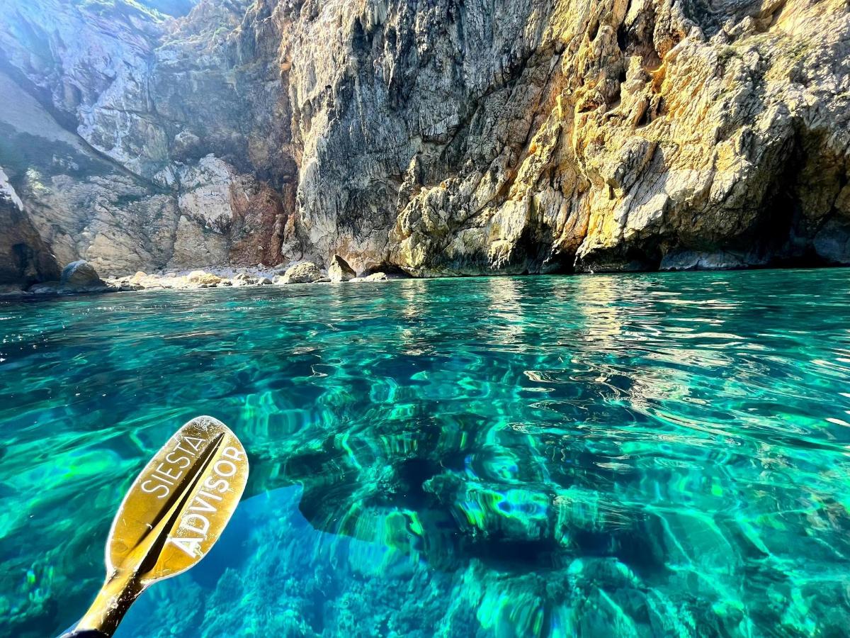 a kayak in the water next to a cliff