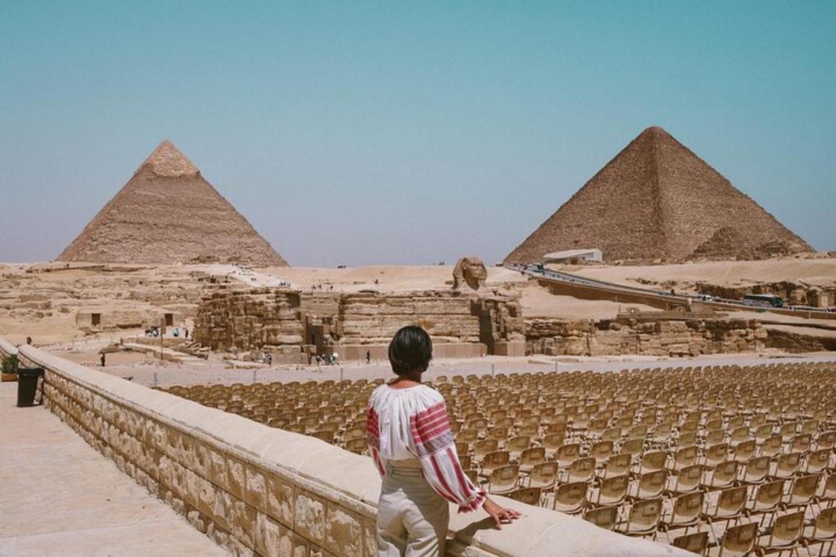 osoba stojící na zdi a dívající se na pyramidy