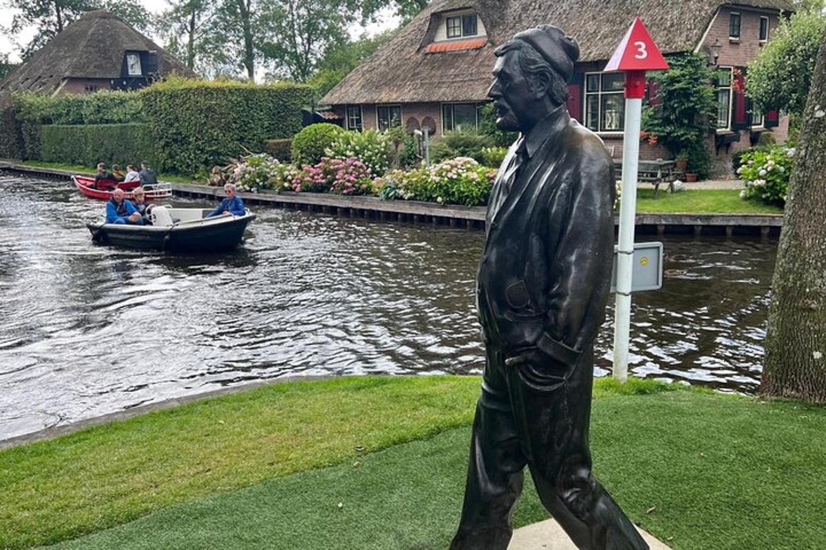 una estàtua d'un home caminant davant d'un vaixell
