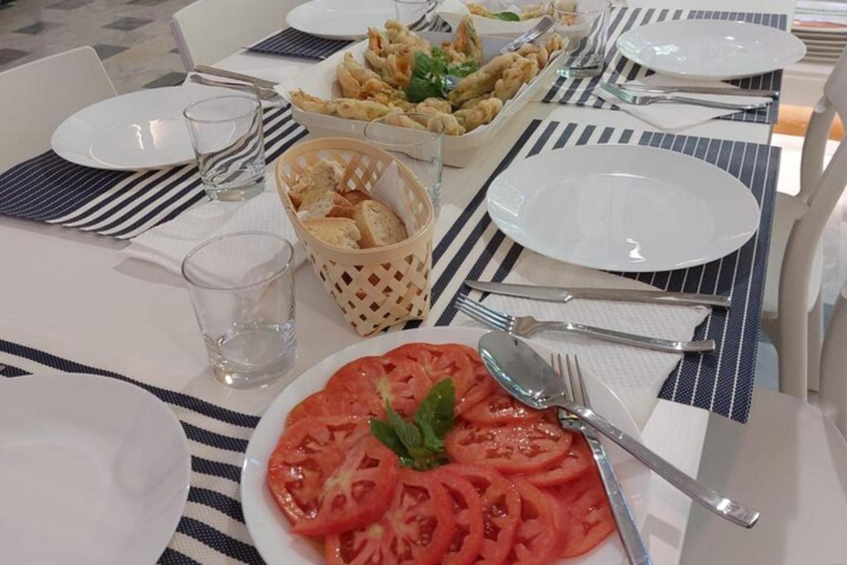 ein Tisch mit einem Teller Tomaten und Pommes Frites