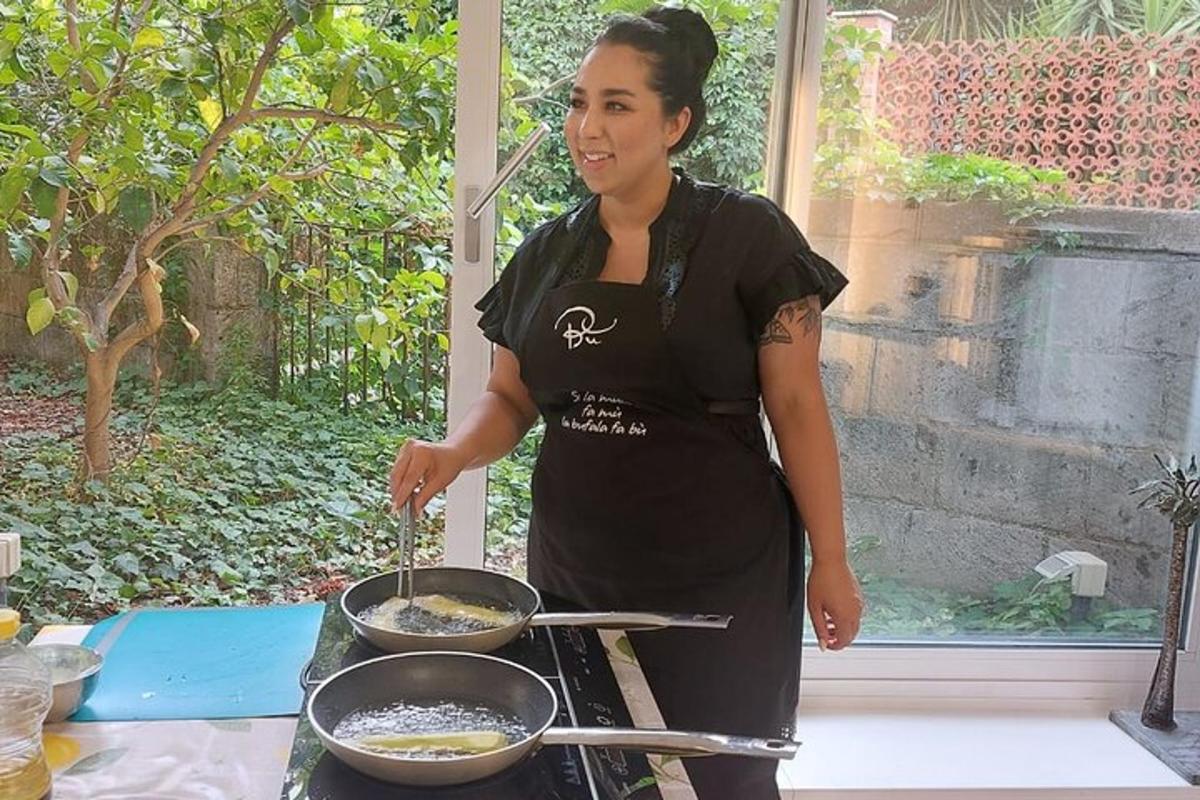 eine Frau, die Essen in einer Pfanne auf einem Grill kocht