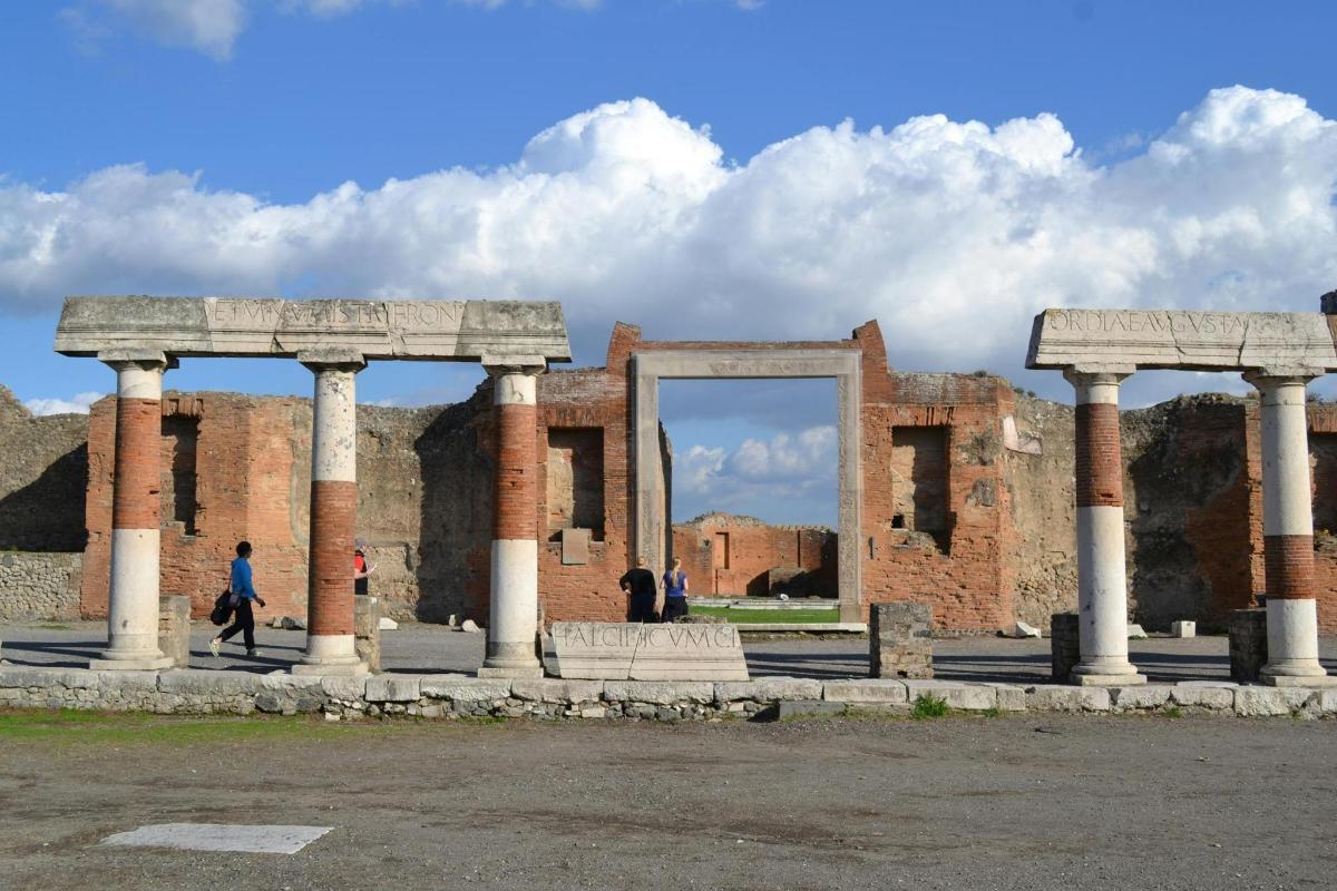 a building with columns and a mirror in front of it