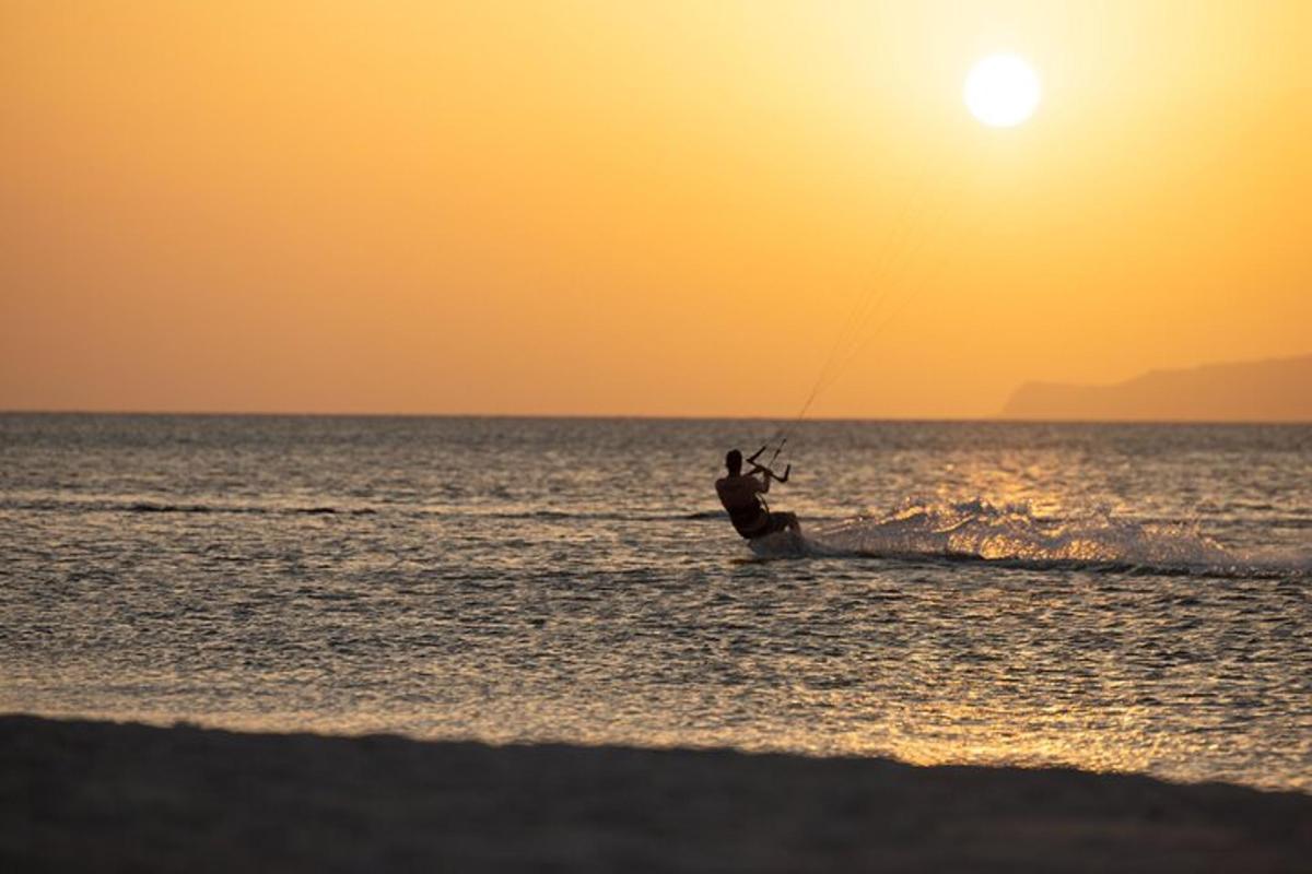 un uomo che fa kitesurf nell'oceano al tramonto