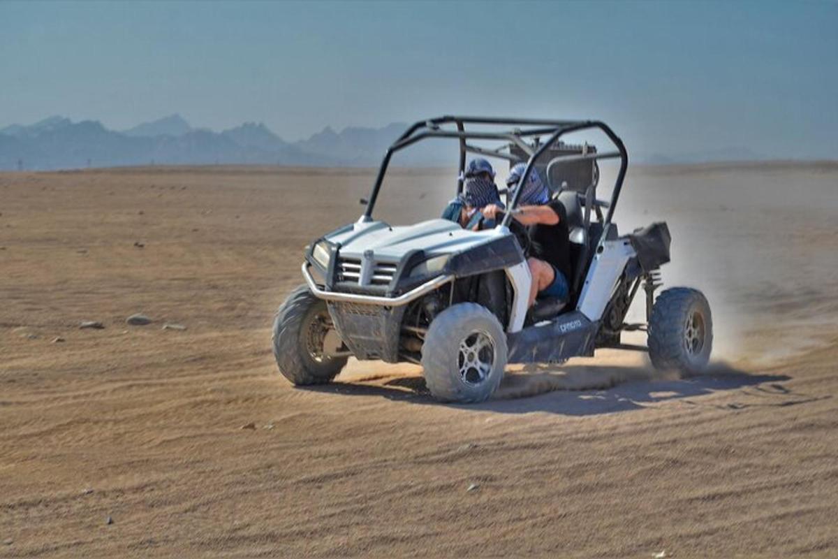 a person driving a quad bike in the desert