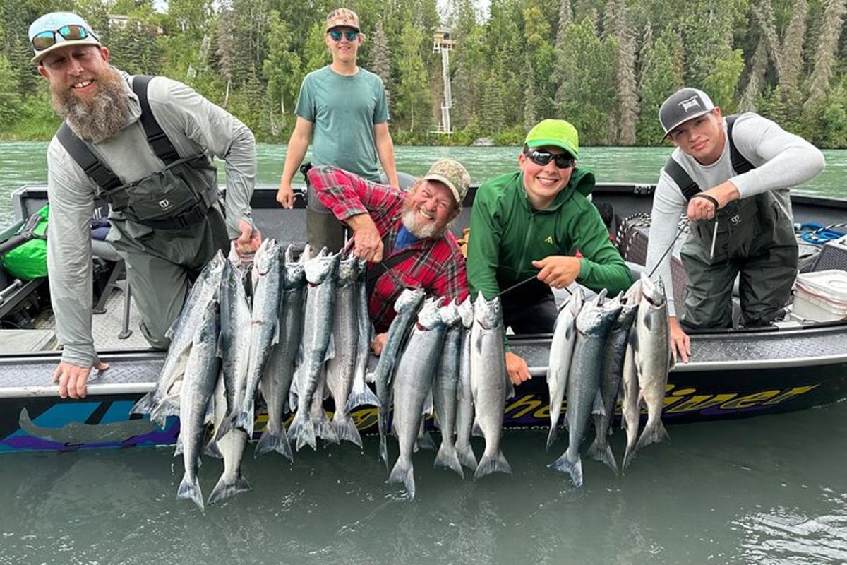 a group of people on a boat holding a bunch of fish