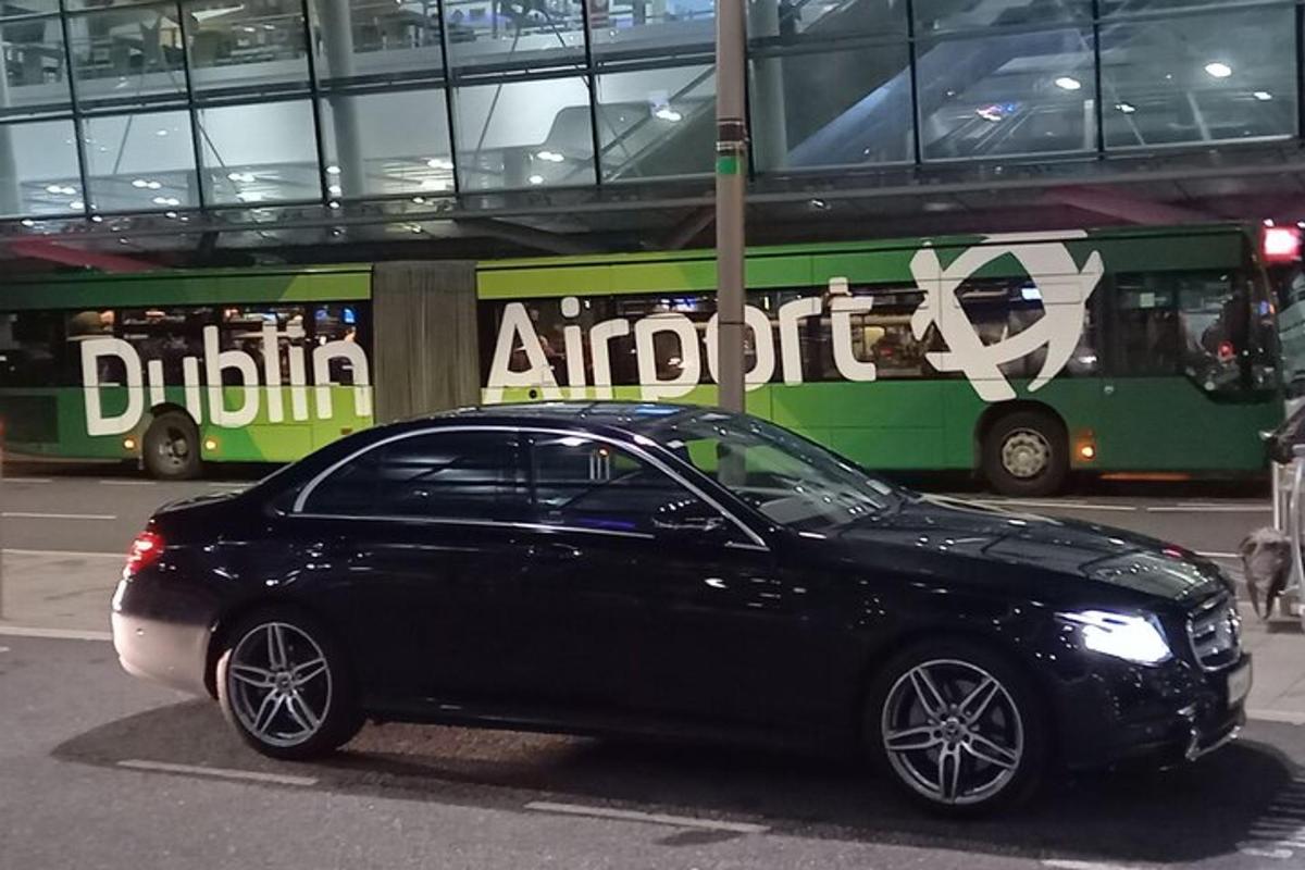 a black car parked in front of a bus