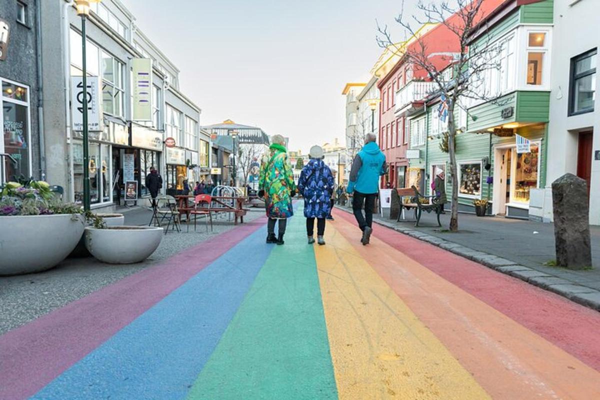 skupina lidí jdoucích po ulici s duhou