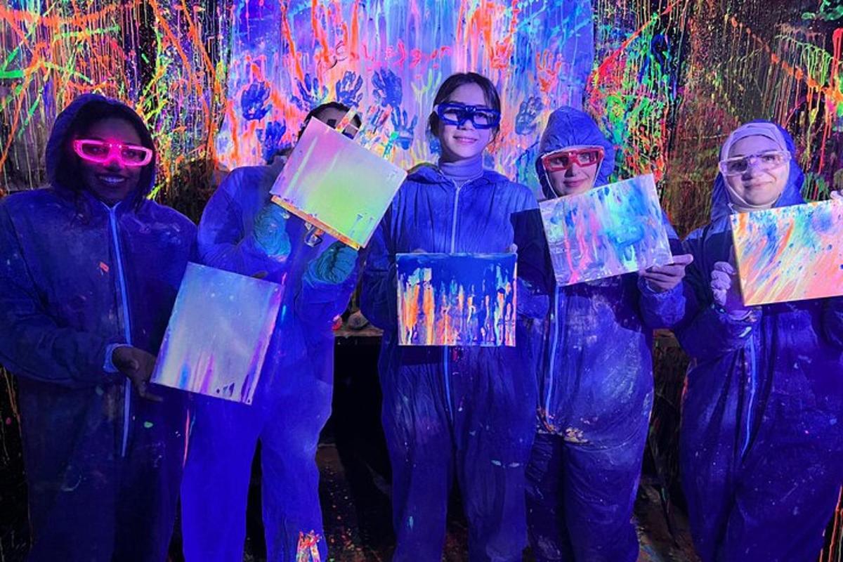 a group of people holding up paintings in front of a wall