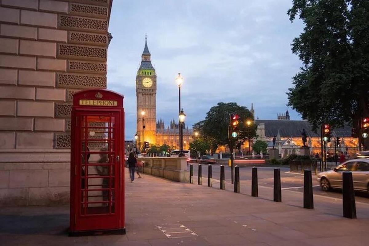 una cabina telefonica rossa su un marciapiede con il Big Ben