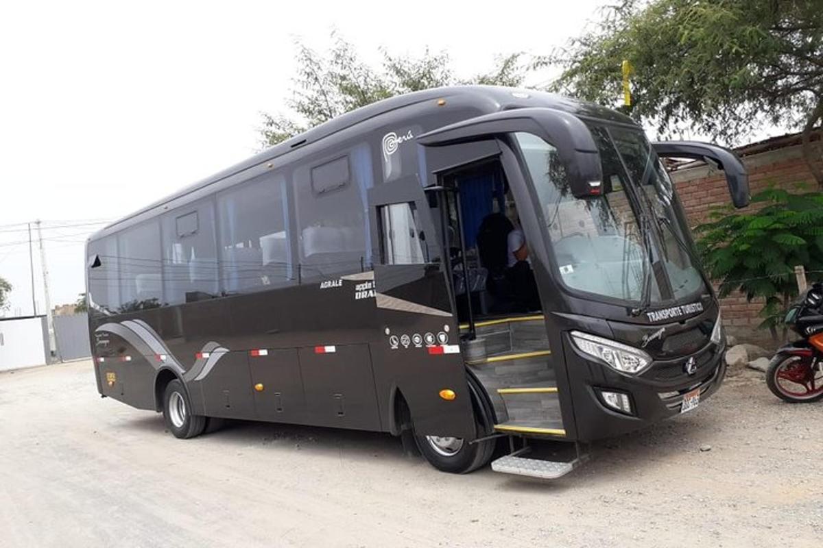 Un autobús negro estacionado con la puerta abierta