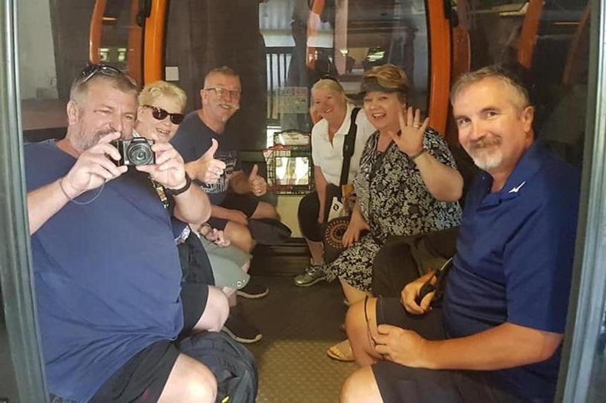 un grup de oameni stând într-un tren cu o cameră foto