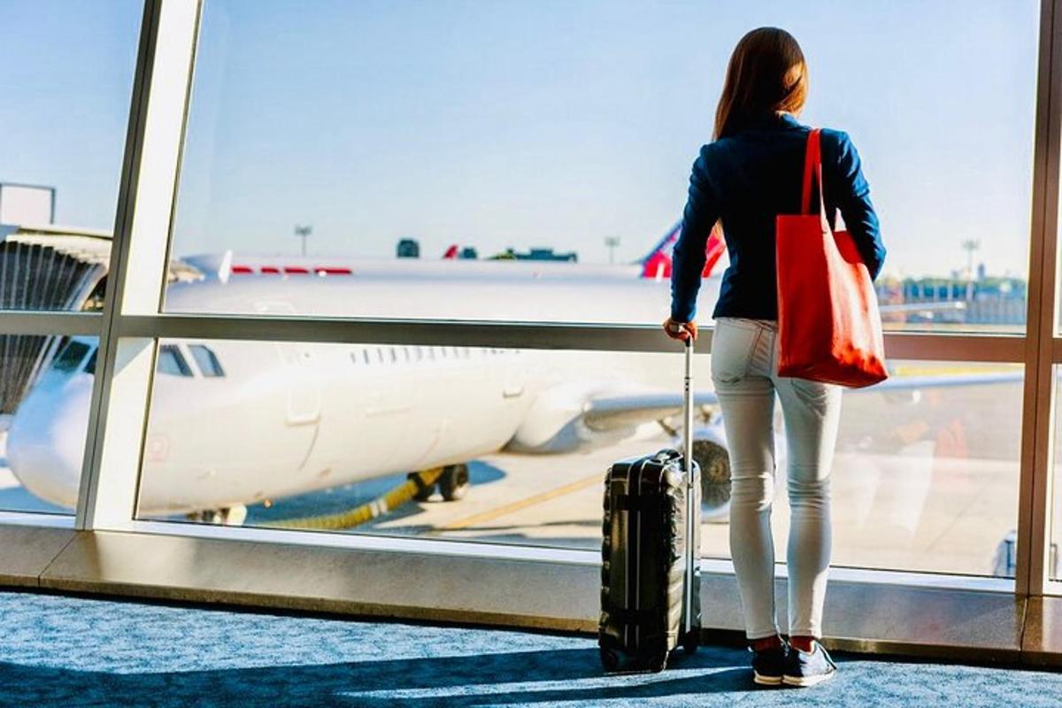 Una mujer mirando por la ventana un avión