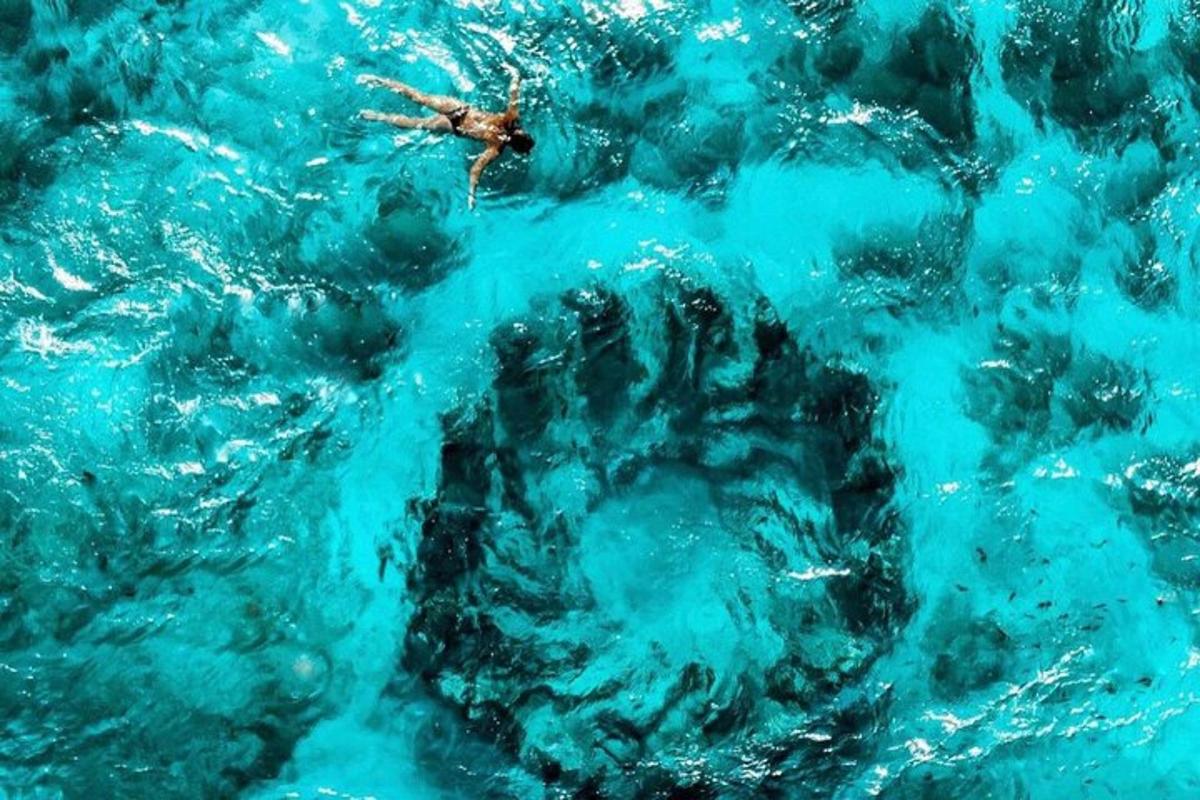 una persona che nuota in una piscina di acqua blu
